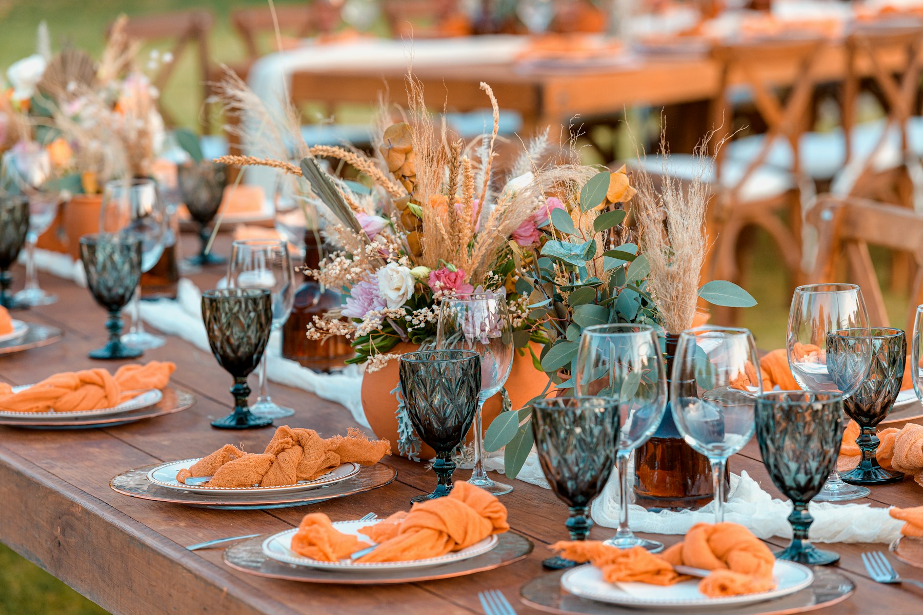 Soft pink and cream flowers arranged with glassware for a celebration